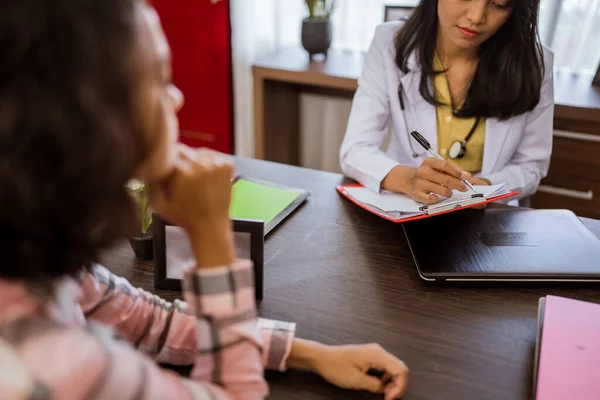 Female Doctor Writing Paper Clipboard Consultation Female Patient Room Background — 图库照片
