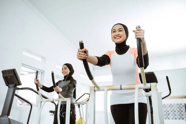 Two Beautiful Woman Hijab Gym Exercising Friend Static Elliptical Cycle — Fotografia de Stock