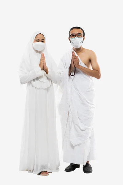 Couple Wearing Hajj Ihram Clothes Masks Greeting Gesture Standing Isolated — стоковое фото