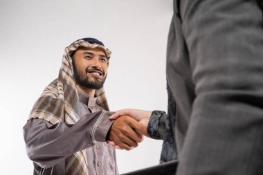 asian muslim man and woman shaking hand. partnership greeting over white background