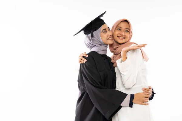 Happy Asian Female Graduate Student Wearing Toga Hugging Her Friend — Stok fotoğraf