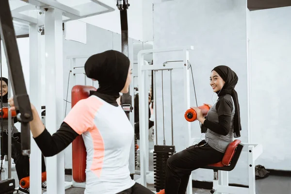 muslim asian woman using chest press machine during fitness at the gym