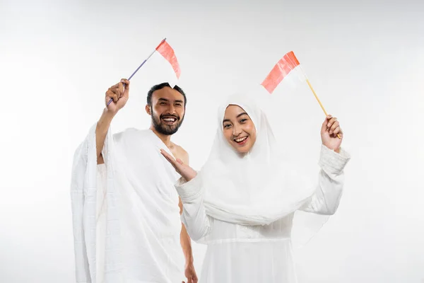 Excited Couple Prospective Hajj Pilgrims Carrying Indonesian Flags Standing Isolated — Stok Foto