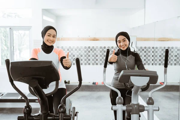 Two Beautiful Woman Hijab Gym Using Static Elliptical Cycle Machine — Stock fotografie