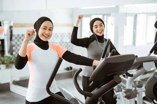 Excited Beautiful Woman Hijab Gym Exercising Friend Static Elliptical Cycle — Stok fotoğraf