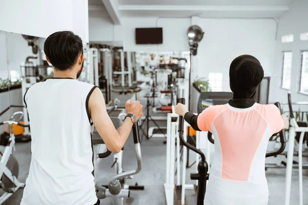 Muslim Couple Using Elliptical Cycle Machine Exercising Together Gym — Stok fotoğraf