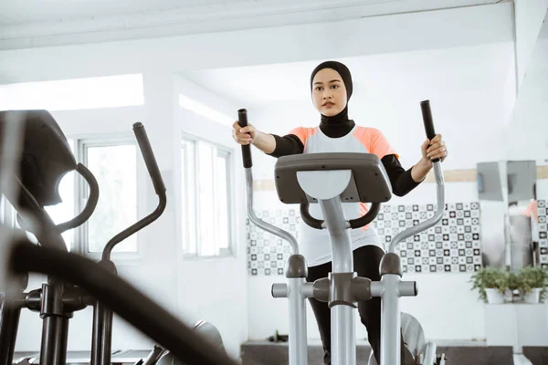 Muslim Women Gym Doing Cardio Exercises Static Elliptical Cycle Machine — стоковое фото