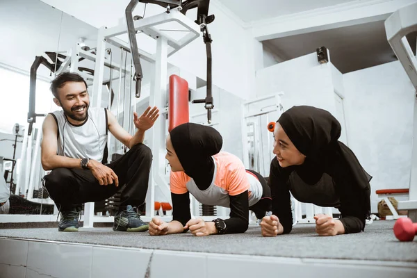 Two Muslim Woman Doing Plank Gym Trainer Teaching Them — Φωτογραφία Αρχείου