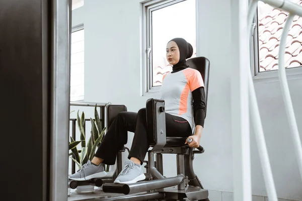 Muslim Asian Woman Working Her Lower Body Using Leg Machine — Stockfoto