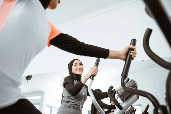 Two Beautiful Woman Hijab Gym Exercising Friend Static Elliptical Cycle — стоковое фото