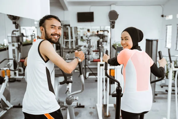 Muslim Couple Using Elliptical Cycle Machine Exercising Together Gym — Stock fotografie