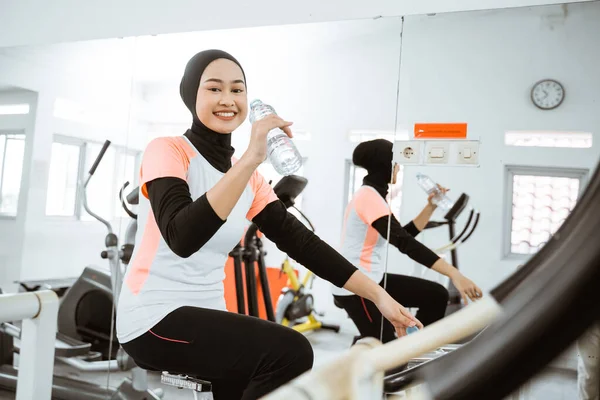 Beautiful Muslim Woman Drinking Bottle Water While Exercising Using Static — Foto Stock