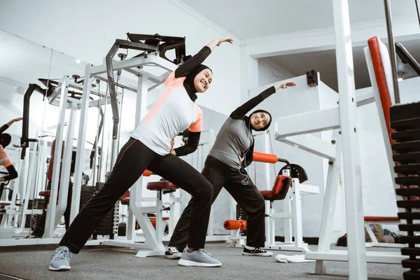 Two Beautiful Muslim Woman Stretching Exercising Gym Together — 스톡 사진