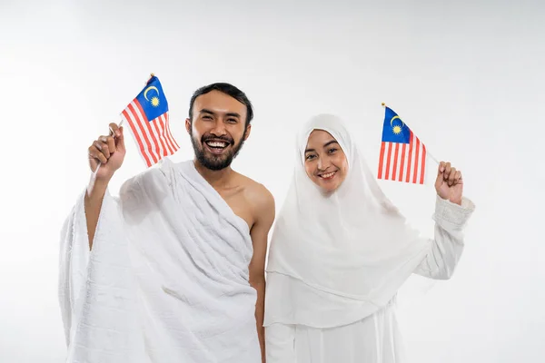 Smiling Asian Couple Wearing Ihram Clothes Carrying Small Malaysian Flag — Stok Foto