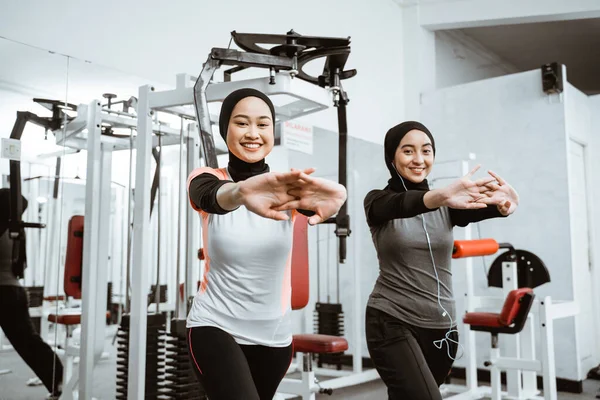 Two Beautiful Muslim Woman Stretching Exercising Gym Together — Stok fotoğraf