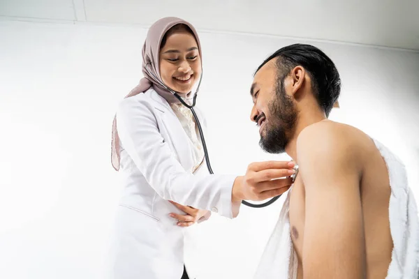 Female Doctor Using Stethoscope Examining Male Pilgrims Isolated Background — Stockfoto