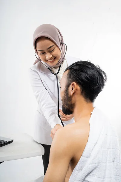 Female Doctor Using Stethoscope Examining Male Prospective Hajj Pilgrims Isolated — Stockfoto