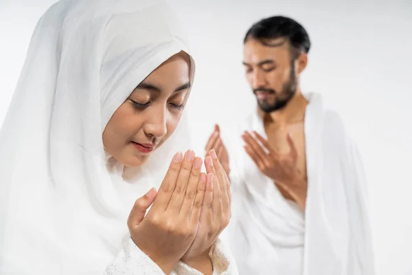 Muslim husband and wife praying to Allah on isolated background