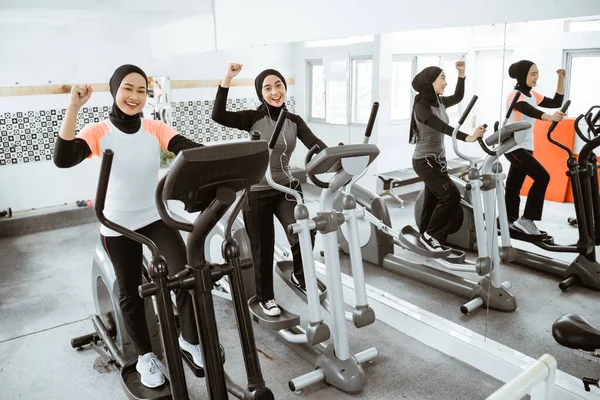 Excited Beautiful Woman Hijab Gym Exercising Friend Static Elliptical Cycle — 스톡 사진