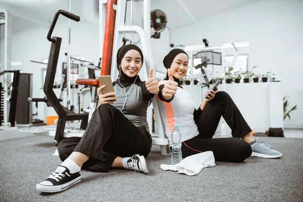 Two Beautiful Muslim Sporty Woman Taking Break Exercising Gym Sitting — 스톡 사진