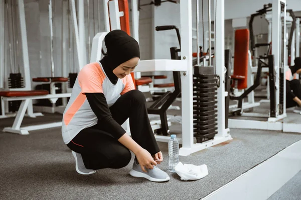 Beautiful Muslim Girl Tying Shoelaces Sports Shoes Gym — Stockfoto