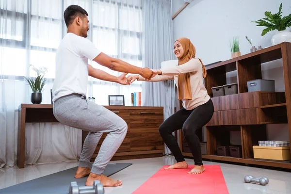 Muslim Couple Exercising Doing Squat Together Facing Each Other Home — Foto de Stock