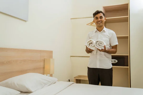 Smiling Young Cleaning Man Holding Towel Standing Hotel Room Bed — Stockfoto
