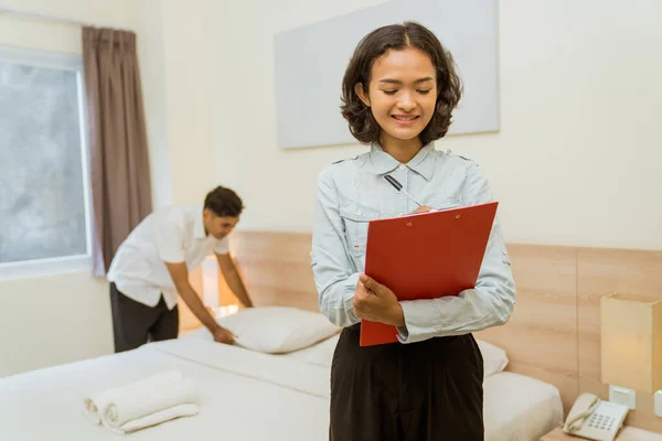 Housekeeping Manager Writing Clipboard Notes Maid Cleaning Hotel Room Background — стоковое фото