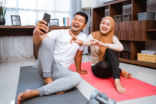 Muslim Couple Using Mobile Phone Together Exercising Home — Foto de Stock