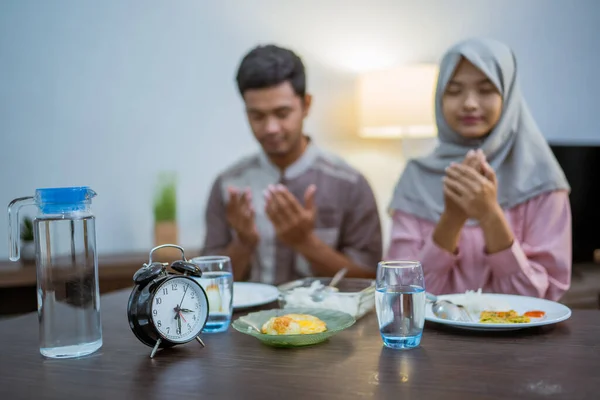 Young Muslim Couple Praying Food Morning Breakfast Ramadan Fasting — стоковое фото