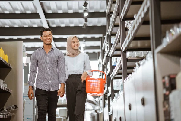 Asian Muslim Young Couple Carrying Baskets Walking Shelves Houseware Store — Stockfoto