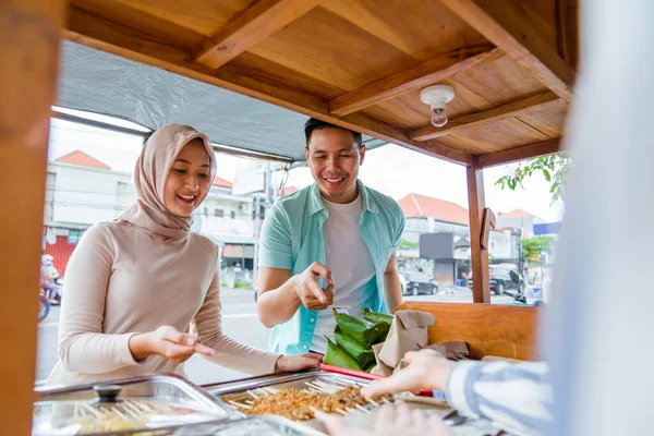 两对穆斯林夫妇在卖方提供的传统食品市场摊位上订购食品以打破禁食 — 图库照片