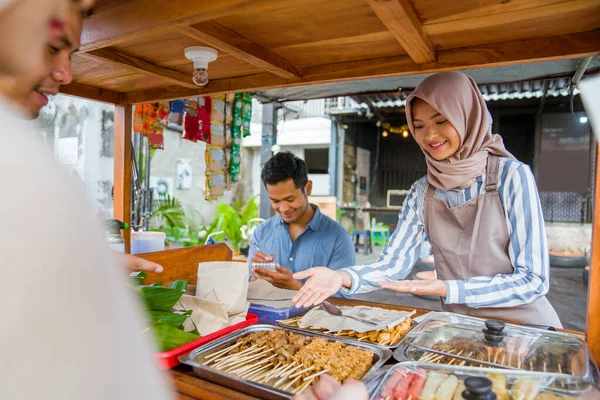 イスラム教徒のカップルは伝統的な屋台で食事を注文して断食をし — ストック写真