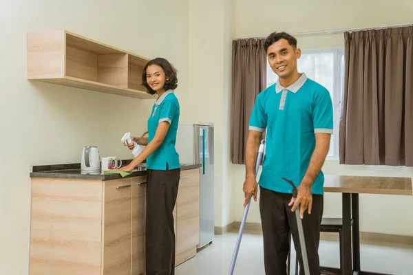 Male Female Janitor Turquoise Uniform Sweeping Cleaning Hotel Room — стоковое фото