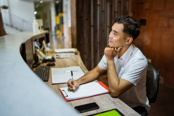 Receptionist Uses Pen Write While Sitting Hotel Reception Desk —  Fotos de Stock