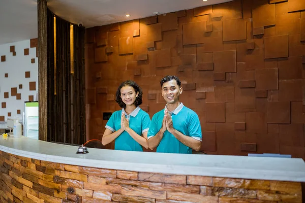 Two Employees Wearing Turquoise Uniforms Smiling Hand Gestures Greeting Welcome — ストック写真
