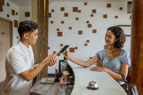 Female Guest Showing Smartphone Receptionist Proof Booking Hotel Lobby — Zdjęcie stockowe