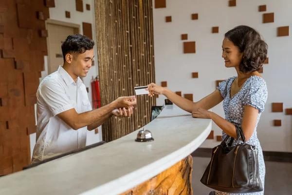 Female Guest Gives Credit Card Hotel Receptionist Checking Lobby — Fotografia de Stock