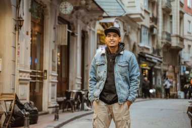 portrait of young male with denim jacket walking on historical city of istanbul