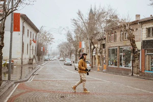 asian man walking in historical old town in istanbul during snow winter season