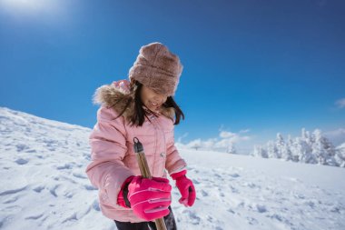 happy little girl playing outside in the snow