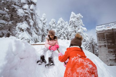 two girl playing with snow. asian little sister enjoy their time in snowy winter together