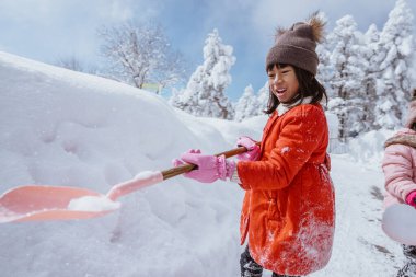 happy little girl playing outside in the snow