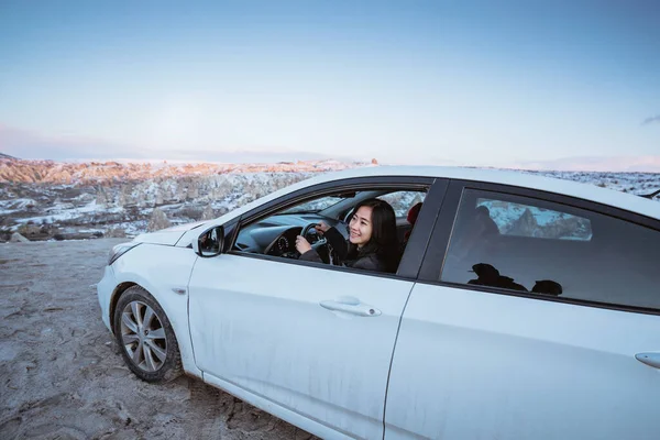 woman driving a car off road to a beautiful landscape in cappadocia turkey