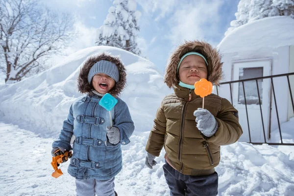 Two Little Kid Licking Lollipop While Standing Snow Outdoor — 스톡 사진