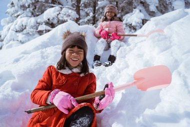 two girl playing with snow. asian little sister enjoy their time in snowy winter together