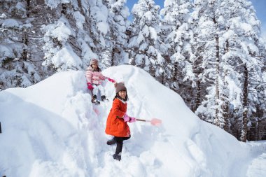 two girl playing with snow. asian little sister enjoy their time in snowy winter together