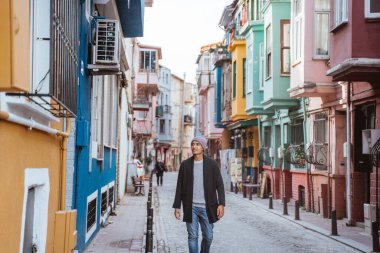 happy young asian man exploring the old city by walking