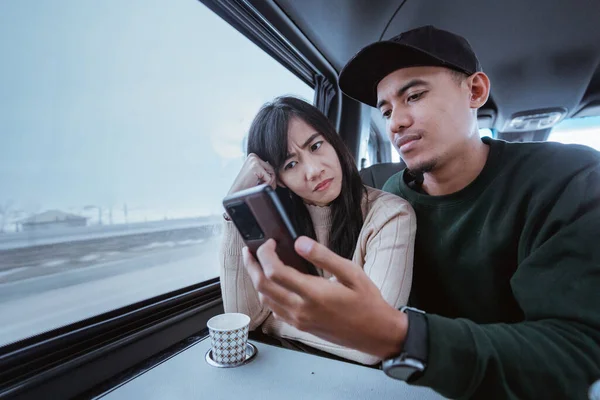 Serious Couple While Looking Mobile Phone Journey Car Van —  Fotos de Stock