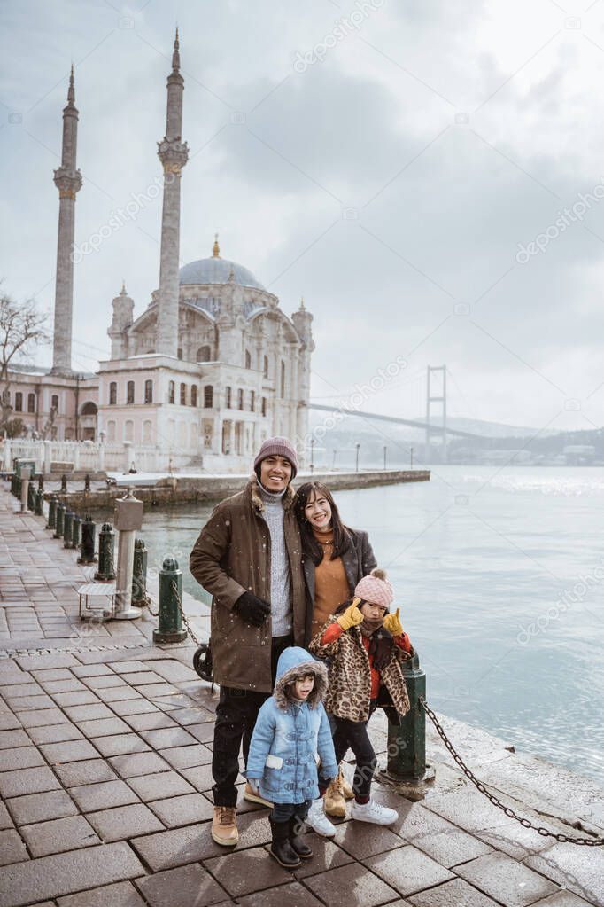 family portrait in front of beautiful ortakoy mosque in turkey